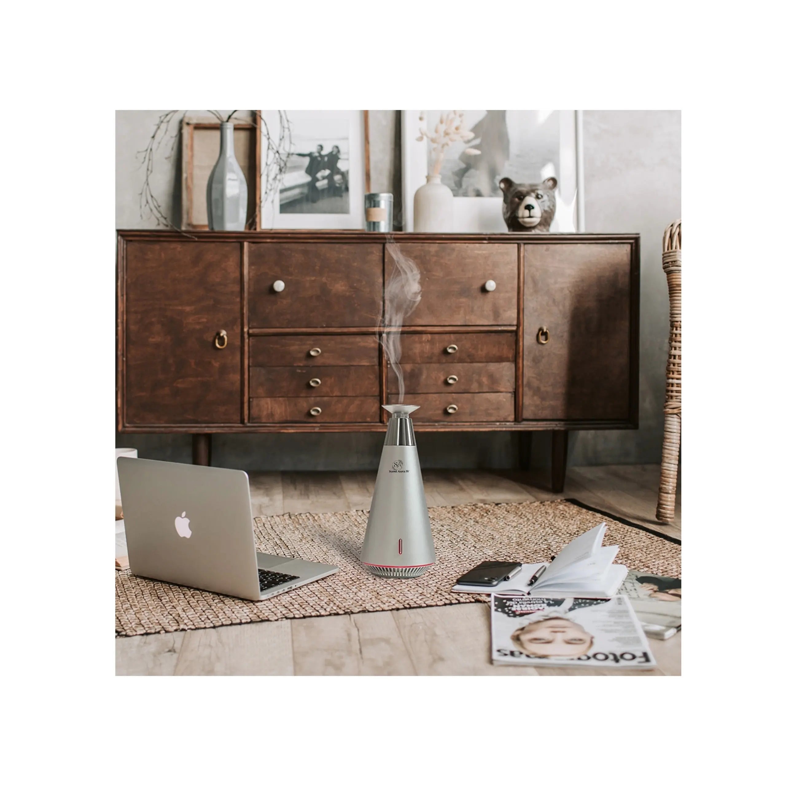 Laptop on a wooden floor with a diffuser emitting steam, a dresser in the background.